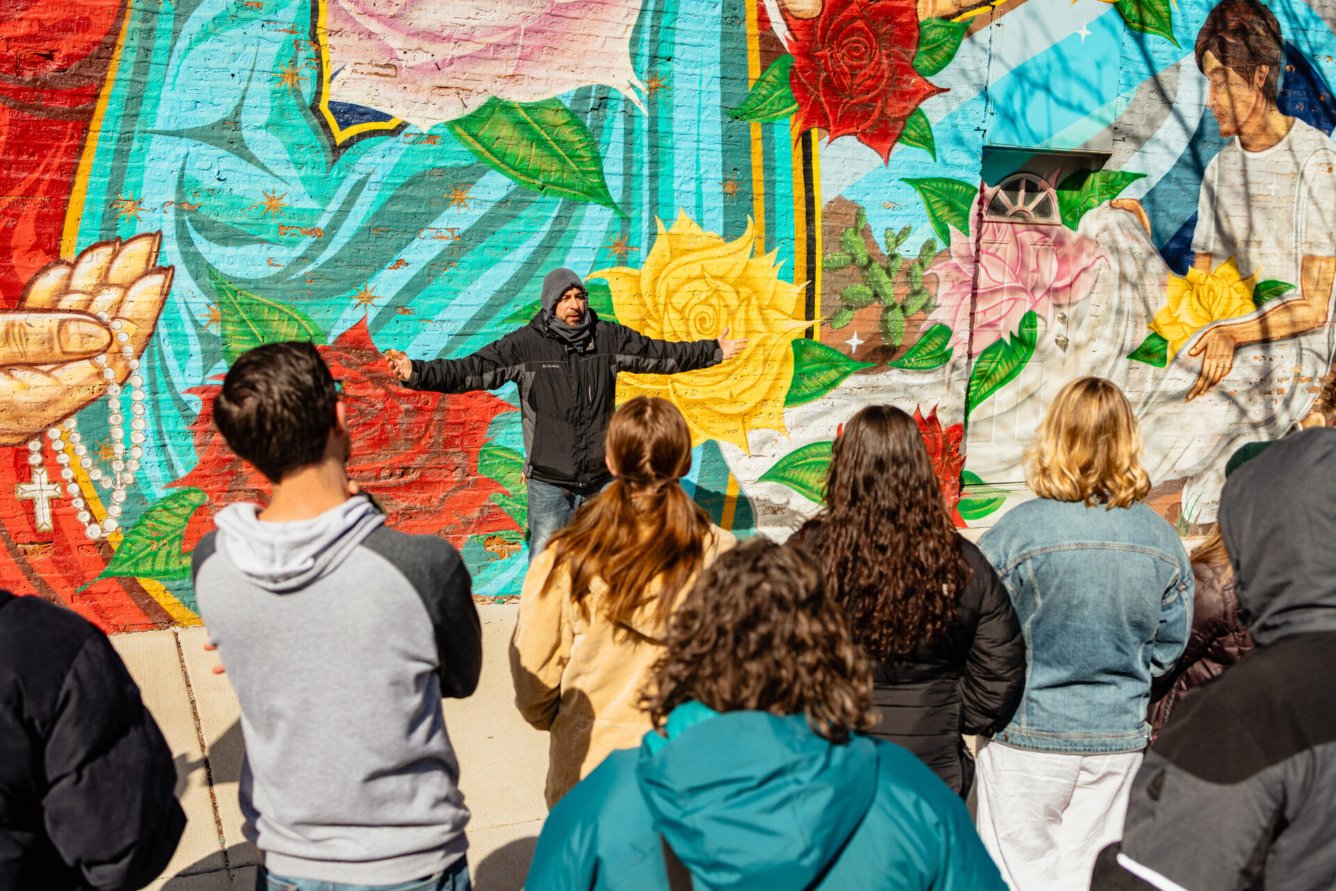students in front of a large mural in Pilsen